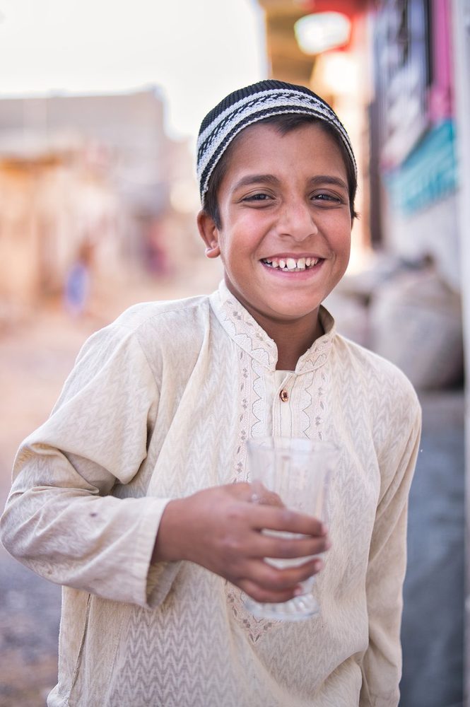 A boy with a cup of clean water from a CDRS project