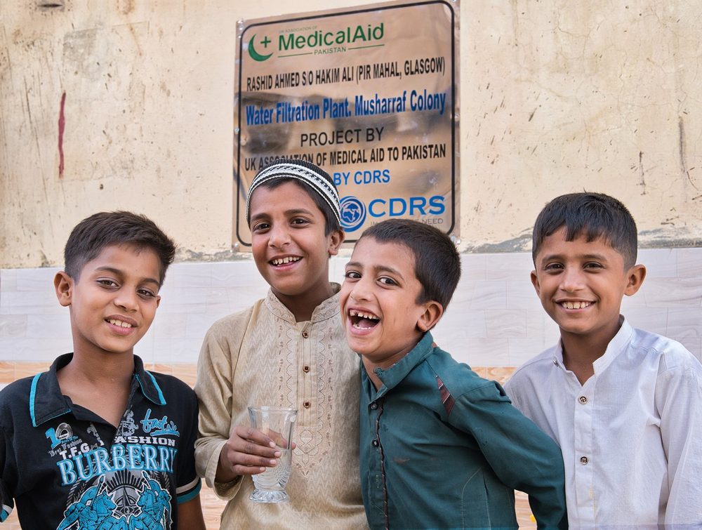 Boys drinking at a CDRS clean drinking water project