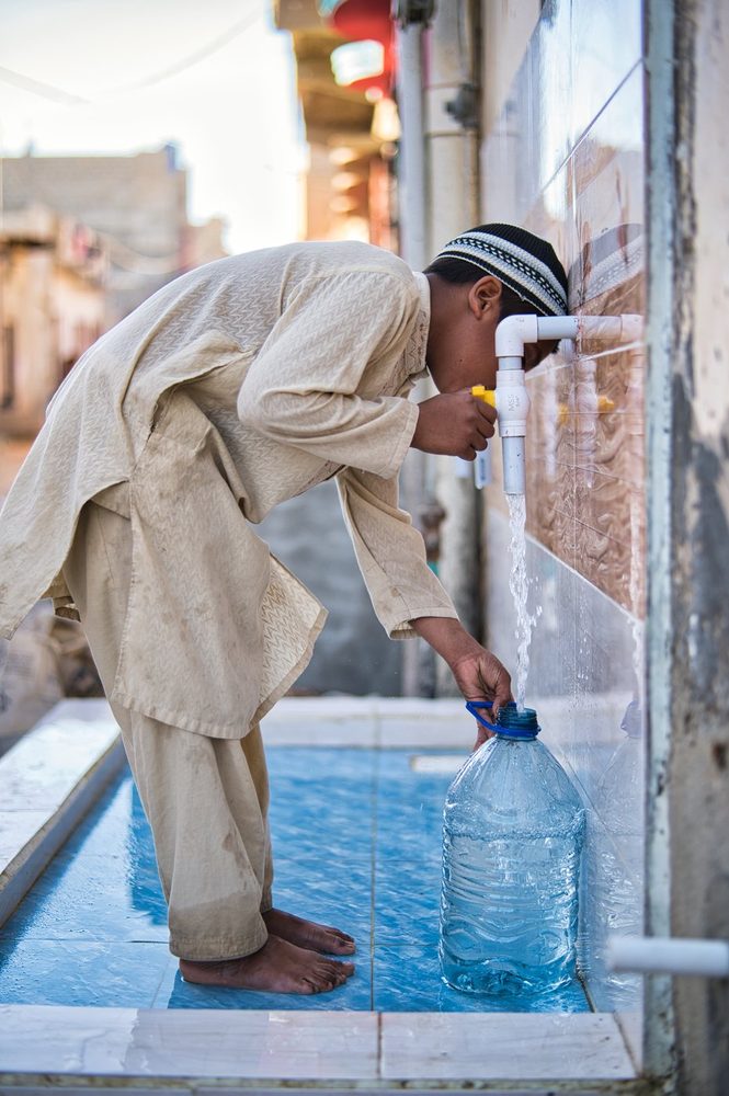 A man filling a container at a CDRS water point
