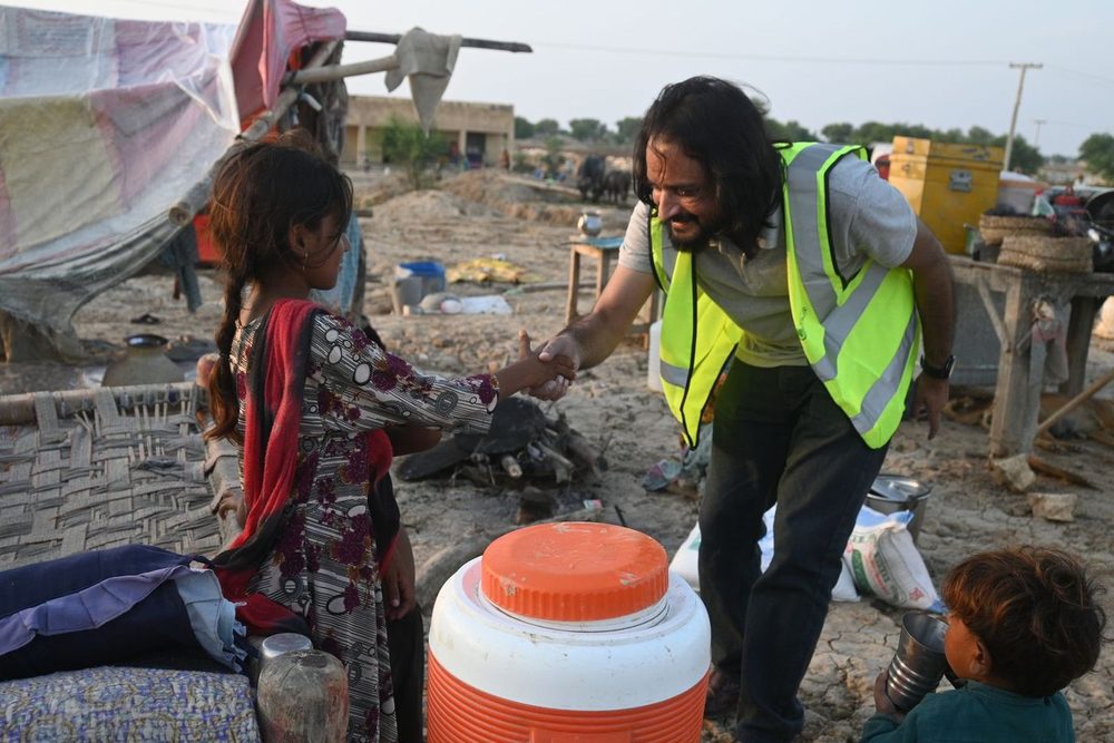 CDRS staff handing clean water containers to a family