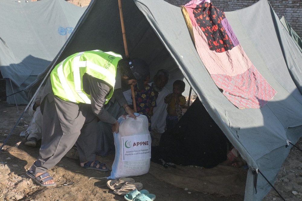 A CDRS team member delivering a ration pack to a tent
