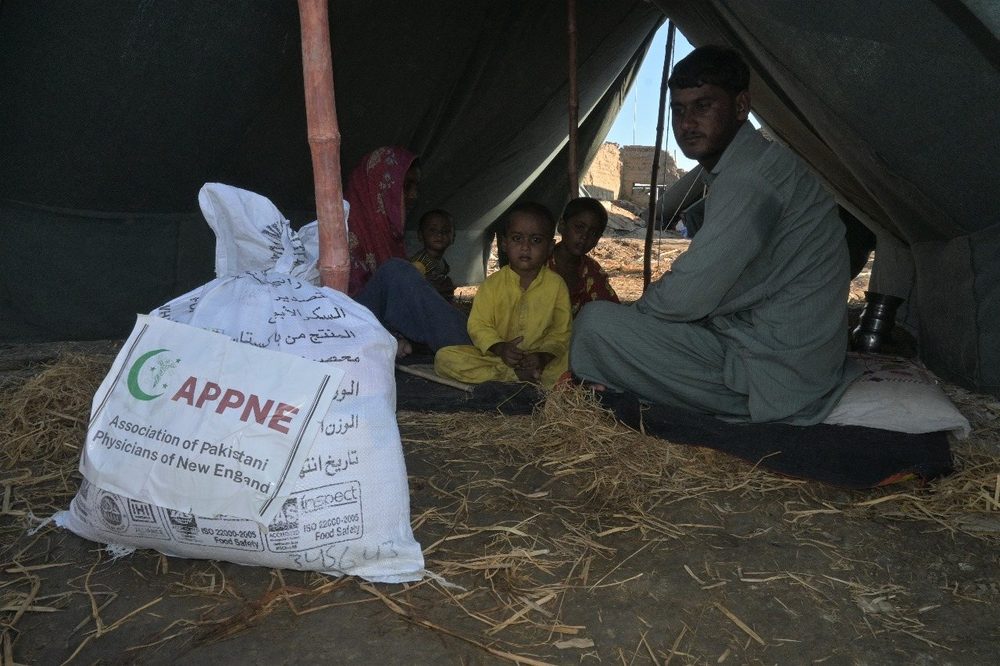 A family with their ration pack inside a relief tent