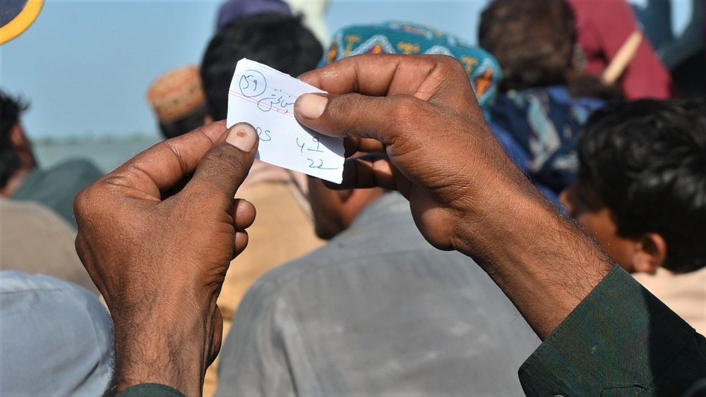 A flood relief distribution token being handed over