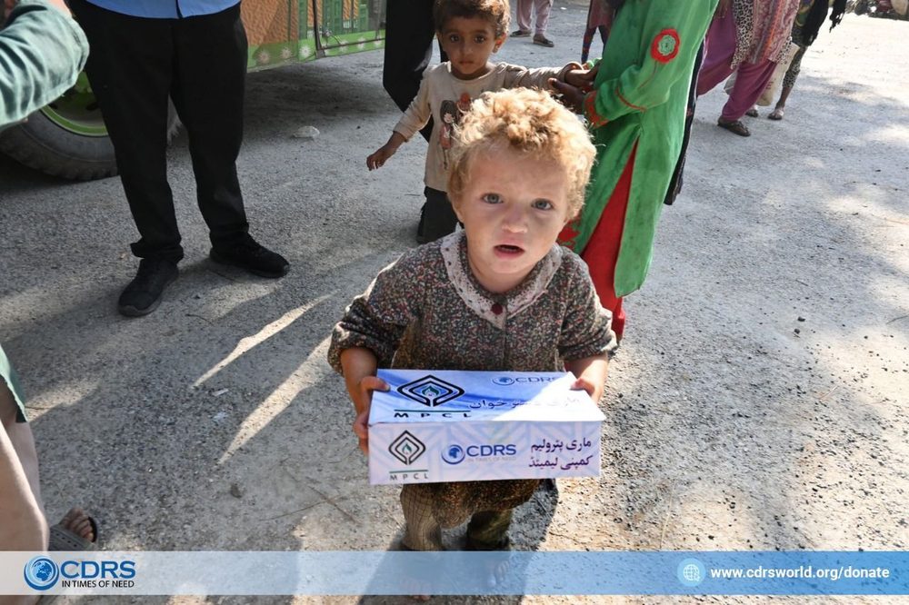 A small child carrying a CDRS family ration box