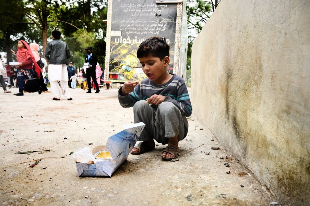 A boy eating a Mari Dastarkhwan meal