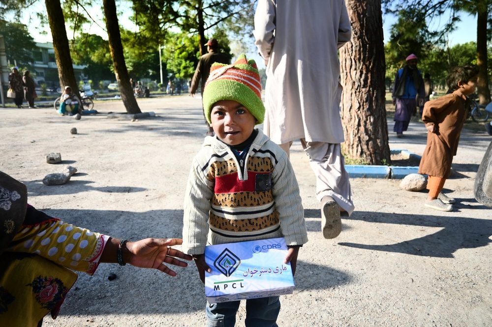 A boy receiving a Mari Dastarkhwan meal