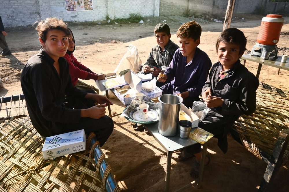 Young men sharing a Mari Dastarkhwan meal