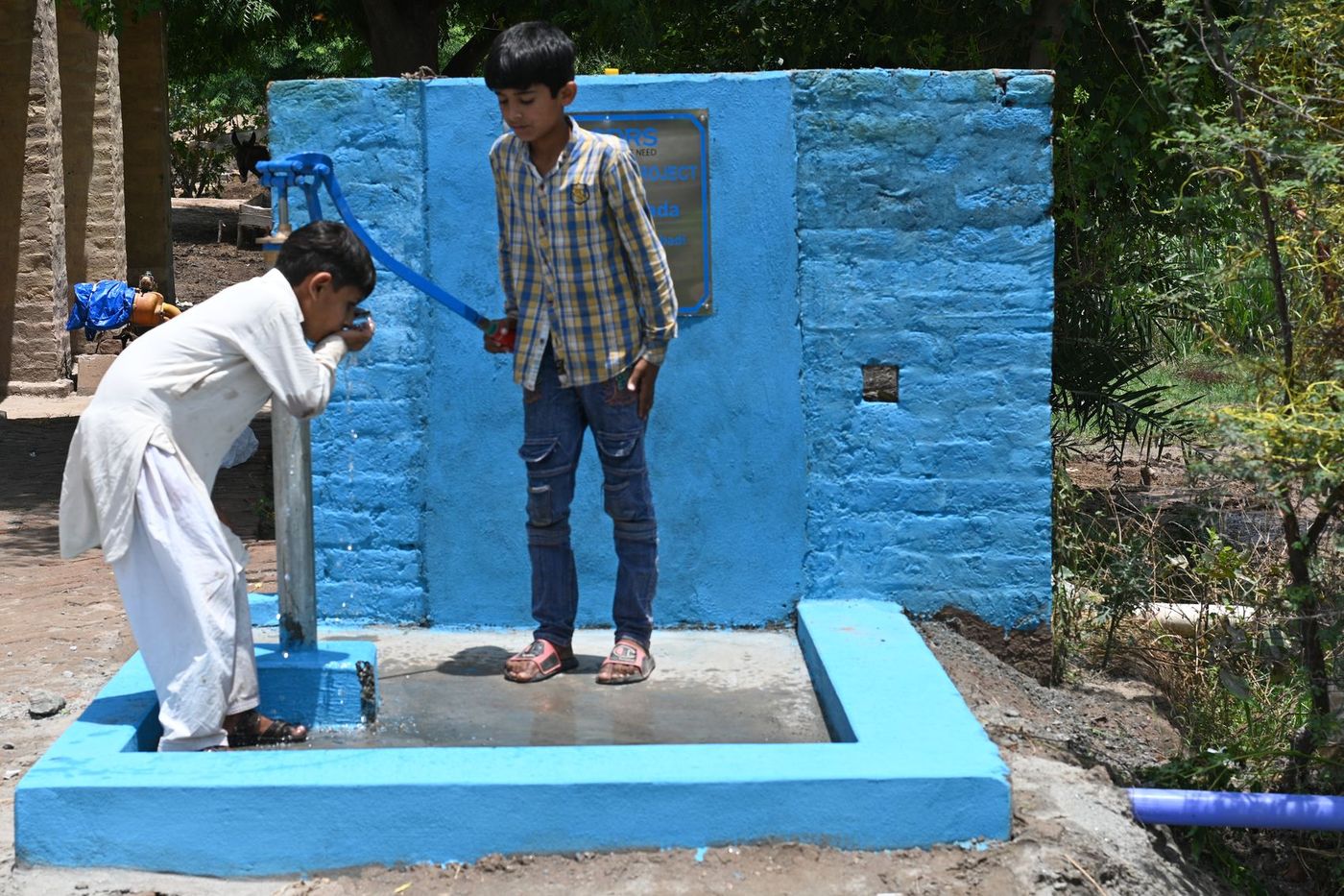 Two women collecting water at a CDRS-built village hand pump